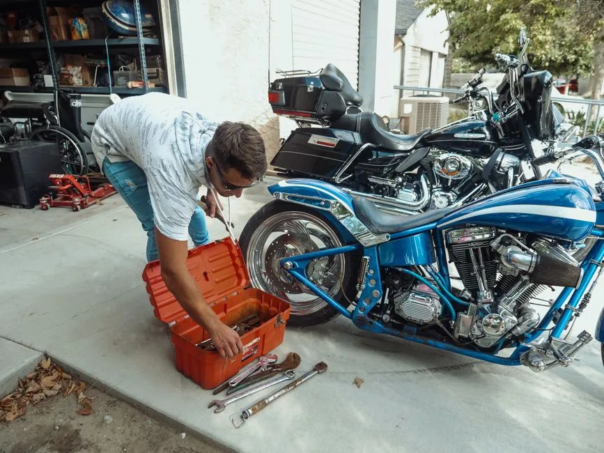 Une moto garée dans un atelier, outils au mur.